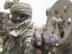 Pour preuve de l'implication soudanaise, un militaire gouvernemental pose sur un blindé de fabrication chinoise. 

		Photo : AFP