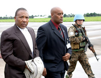 Charles Taylor (à gauche),  lors de son tranfert de Freetown (Sierra Léone) vers le tribunal international de La Haye (Pays-Bas) où il doit être jugé pour crimes contre l’humanité. 

		(Photo: Special Court for Sierra Leone)