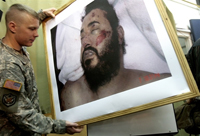 Un soldat américain montre la photo de Zarqaoui, mort. 

		(Photo : AFP)