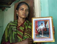 La veuve de Chandrakant Gurenule, un petit producteur de coton, montre le portrait de son mari, suicidé à 34 ans.  

		(Photo : AFP)