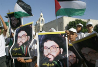 Bethléhem, le 7 août. De jeunes Palestiniens brandissent le portrait d'Hassan Nasrallah lors d'une manifestation contre les opérations militaires israéliennes au Liban et dans la bande de Gaza. 

		(Photo : AFP)