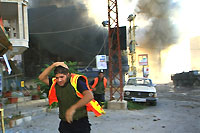 Un employé de la défense civile libanaise court se mettre à l'abri durant un raid israélien sur la ville de Tyr, le 13 août 2006.(Photo: AFP)