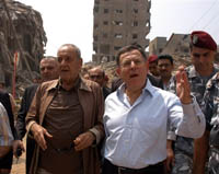 Le Premier ministre libanais Fouad Siniora (à droite) avec le président du Parlement Nabih Berri dans les décombres de la banlieue sud de Beyrouth, le 20 août. Nabih Berri soupçonne le gouvernement de vouloir faire porter au Hezbollah la responsabilité du blocus. 

		(Photo : AFP)