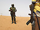 Un soldat de l'Union africaine (à g.) patrouille près du village de Fakili. 

		(Photo: AFP)