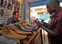 Vente de chaussures confectionnées en Chine dans une échoppe de Kampala en Ouganda.  Le commerce bilatéral Chine-Afrique devrait dépasser 50 milliards de dollars en 2006. 

		(Photo: AFP)