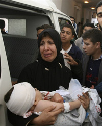 Une femme palestinienne avec son enfant blessé à l'hopital Beit Lahia à Gaza suite à l'attaque israélienne contre Beit Hanoun. 

		(Photo : AFP)