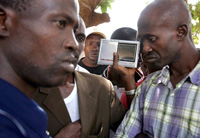 Des manifestants guinéens écoutent les informations à la radio, le 23 janvier à Conakry. 

		(Photo: AFP)