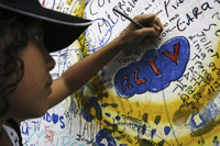 Dimanche 27 mai 2007, une jeune supportrice écrit un message de soutien sur les murs de la RCTV à Caracas. 

		(Photo : Reuters)