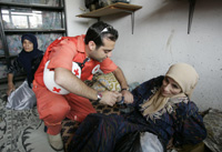 Un membre de la Croix-Rouge libanaise aide une palestinienne près du camp de Nahr al-Bared, au nord du Liban. 

		(Photo : Reuters)