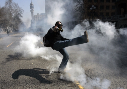 Un manifestant renvoie une grenade de gaz lacrymogène durant les affrontements qui ont marqué la journée du 29 août à Santiago.(Photo : Reuters)