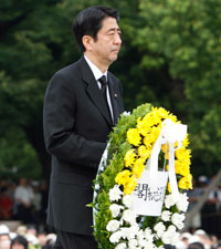 Shinzo Abe déposant une gerbe de fleurs devant le monument aux victimes d'Hiroshima.(Photo : Reuters)