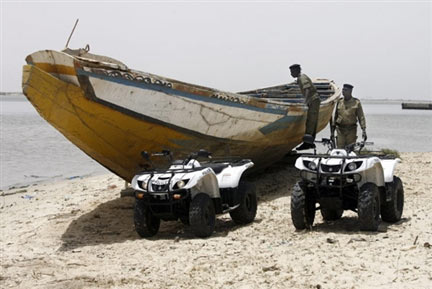 Des policiers sénégalais, lors de l'inspection d'un bateau suspect, pendant une patrouille sur une plage près de la ville de Saint-Louis, le 27 mai 2007.(Photo : AFP)