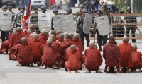 Des moines assis face aux policiers et militaires qui leur barrent l'entrée de la pagode Schwedagon à Rangoon.(Photo : Reuters)