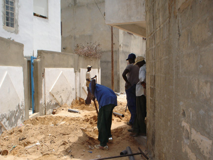 Des ouvriers sur un chantier dans une des ruelles étroites.(Photos : Safiétou Kane)