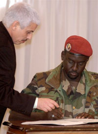 Mahamat Nour Abdulkerim, ministre tchadien de la Défense (d) ex-chef des rebelles du FUC, signant l'accord de paix, à Tripoli, le 24 décembre 2006.(Photo : AFP)