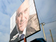 Des habitants du village isolé de Gracanica, au Kosovo, passent sous un panneau d'affichage à l'effigie du candidat de l’extrême droite nationaliste Tomislav Nikolic.(Photo : Reuters)