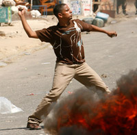 Un manifestant jetant des pierres sur les forces de police, dans la ville de Mombasa, vendredi 18 janvier.(Photo : Reuters)