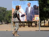 A Ndjamena, un soldat tchadien passe devant une affiche du président Idriss Déby et de son épouse. (Photo : AFP)