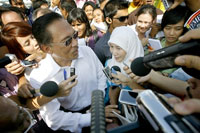 Le chef de l'opposition Anwar Ibrahim (g) avec son épouse, Wan Azizah Ismail, présidente du Parti de la justice et du peuple, en mars 2008 à la sortie du bureau de vote.(Photo : AFP)