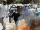  Un homme guide un écolier à travers les émeutes et le feu à Nairobi.(Photo: Reuters)