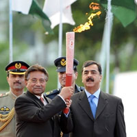 Le président pakistanais, Pervez Musharraf (g) tient la flamme olympique. A droite le Premier ministre Yousouf Raza Gilani.(Photo : AFP)