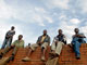 Des immigrés du Malawi, attendent sur le mur du commissariat de police à Durban, le bus qui les ramènera chez eux, le 27 mai 2008.(Photo: Reuters)