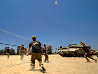 Des soldats israéliens jouent au volley-ball sur une base militaire, près du poste-frontière de Kissoufim, dans la bande de Gaza, mercredi 18 juin.(Photo : Reuters)