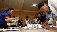 Dans un bureau de vote à Phnom Penh pendant les élections législatives, des fonctionnaires comptent les bulletins du scrutin, le 27&nbsp;juillet 2008.(Photo : Reuters)
