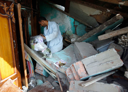 Un homme dans les décombres de sa maison détruite est à la recherche d'effets personnels, le 7 septembre 2008.(Photo: Reuters)