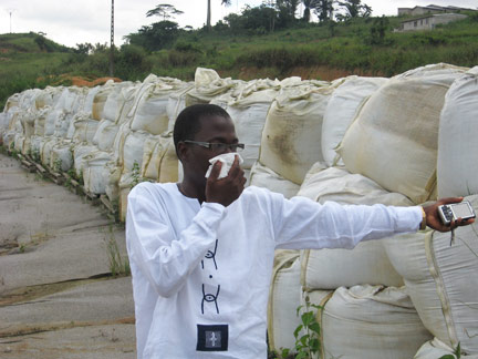 Denis Yao Pipira, président de la Fédération des associations des victimes des déchets toxiques de Côte d'Ivoire montre les sacs de terre contaminée. 
(Photo : N. Navarro/RFI)
