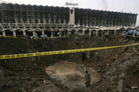 Les soldats et policiers pakistanais examinent le cratère causé par l'attentat à la bombe contre l'hôtel Marriott.(Photo : Reuters)