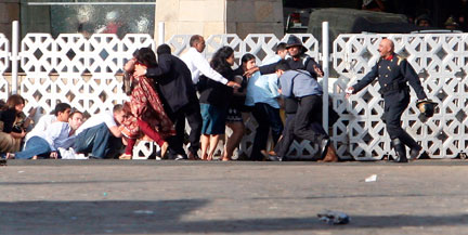 Un groupe de personnes tentent de se mettre à l’abri des tirs provenant de l’hôtel Taj mahal de Bombay, le 27 novembre 2008. (Photo : Reuters)