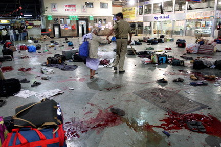 Un policier accompagne une victime, après la fusillade, dans la gare de Bombay, en Inde, le 26 novembre 2008.(Photo : Reuters)