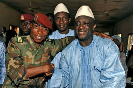 Moussa Dadis Camara (à gauche) serre la main du ministre de la Défense Almamy Kebele, en compagnie du Premier ministre Ahmed Tidiane (en arrière au centre), le 25 décembre 2008.(Photo : AFP)