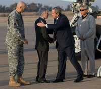 Le président George W. Bush (D) salue Ryan Crocker (C) ambassadeur américain en Irak et le général américain commandant des forces multinationales en Irak (G), lors de son arrivée à Bagdad, le 14&nbsp;décembre 2008.(Photo : AFP)