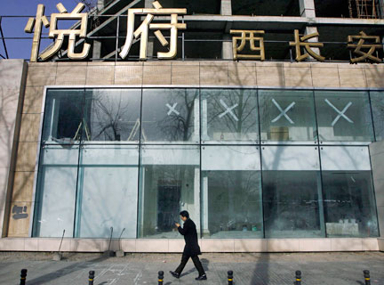 Un homme passe devant une boutique qui a cessé ses activités dans le centre de Pékin, le 22 janvier 2009.( Photo : Reuters )