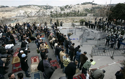 Des Palestiniens prient face aux forces de police israélienne déployées autour de la Vieille Ville de Jérusalem pendant la prière du vendredi, le 2 janvier 2009.(Photo : AFP)