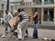 Devant le siège de la radio nationale incendiés par des émeutier, des Malgaches nettoient des débris, le 29 janvier 2009.( Photo : Reuters )