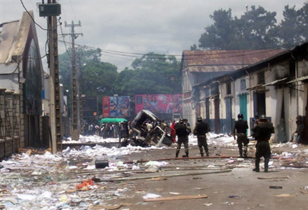 Les forces de sécurité de l'État, le 27 janvier 2009, devant un bâtiment appartenant à la famille du président malgache, Marc Ravalomanana, pillé et brûlé la veille, à Antananarivo.(Photo : AFP)