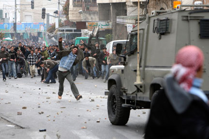 De jeunes palestiniens lancent des pierres contre des soldats israéliens, lors d'une manifestation contre l'offensive israélienne sur Gaza, à Hébron, en Cisjordanie, le 9 janvier 2009.(Photo : Reuters)