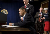 Le président américain Barack Obama signe des décrets sous le regard du vice-président Joe Biden à la Maison Blanche, le 21 janvier 2009.(Photo : AFP)