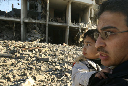Un Palestinien et son enfant, à proximité d'un immeuble qui vient d'être détruit par un raid aérien à Gaza, le 13 janvier 2009.(Photo : Reuters)