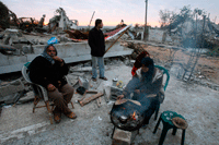 Des habitants palestiniens assis parmi les ruines de leur maison détruite, à Jabalya dans la bande de Gaza du nord, le 20&nbsp;janvier 2009.(Photo : Reuters)