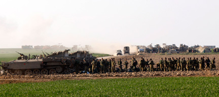 Des soldats israéliens et des véhicules de transport de troupes stationnés juste en dehors de la bande de Gaza, le 12 janvier 2009.(Photo : Reuters)