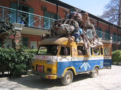 Représentation d'un «&nbsp;car-rapide&nbsp;» surchargé, par un artiste lors d'une exposition à Dakar, en 2002.(Photo : Wikimédia)