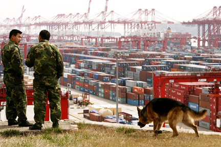 Deux agents de sécurité, devant le port de Shanghai, où sont stockés des conteneurs, le 8 mars 2009. (Photo : Reuters)