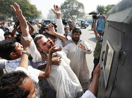 A Karachi, des policiers en civil arrêtent un militant de l’opposition pakistanaise qui participe à la « longue marche », le 12 mars.(Photo : Reuters)