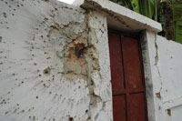 Le mur d’enceinte de la maison de Nino Vieira, transpercé par un tir d’arme lourde.(Photo : L. Correau/RFI)