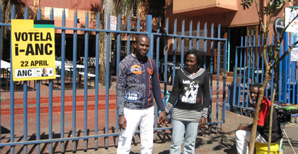 Flavie et Daniel devant leur immeuble, avec une affiche électorale de l'ANC.
(Photo : Sarah Tisseyre / RFI)