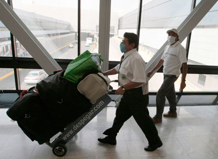 L'OMS ne croit pas à la nécessité de restreindre les déplacements internationaux. Mais les employés de l'aéroport international de Mexico,&nbsp;par mesure de prévention, portent des masques.(Photo : Reuters)